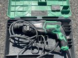 une boîte verte contenant des outils, posée par terre