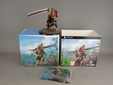 a box with a figurine of a man holding a sword next to a box with a video game