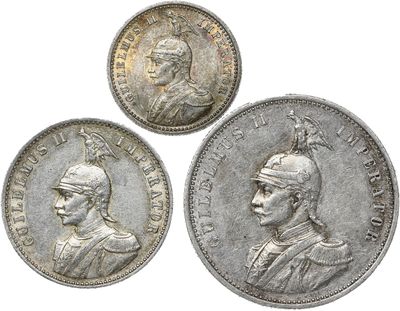 three silver coins, one of which has a head of a man and one of which is wearing a helmet
