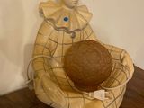 a ceramic figurine of a clown holding a ball on a wooden floor
