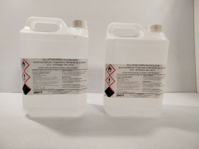 two containers of liquid sitting on top of a white table
