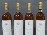 quatre bouteilles de vin sont alignées sur une table