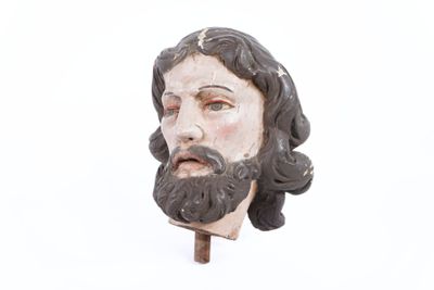 une statue représentant un homme barbu, fixée sur un bâton