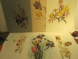 trois tableaux représentant des fleurs et des papillons posés sur une table