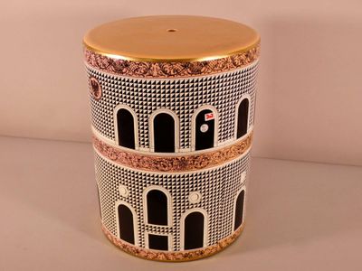 a black and white vase with a gold lid