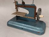 a blue sewing machine sitting on a white surface
