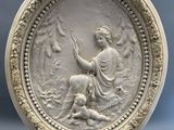 une assiette blanche ornée d'un relief représentant une femme et un homme