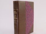 a brown book with a pink cover sitting on a white surface