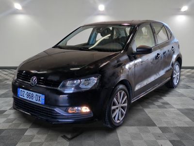 La Volkswagen Polo break noire est garée dans une pièce au sol carrelé en damier.
