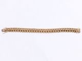 a close up of a gold chain bracelet on a white surface