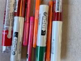 Plusieurs stylos sont alignés sur une table