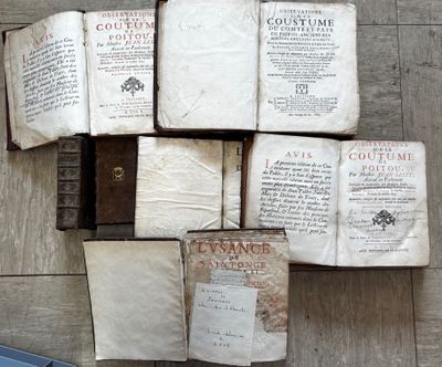 Plusieurs vieux livres sont empilés les uns sur les autres sur un plancher en bois.