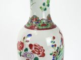 un vase blanc orné de fleurs, posé sur un socle