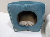 a cat bed that is on the floor next to a pillow
