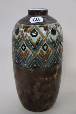 a brown and blue vase sitting on a white surface