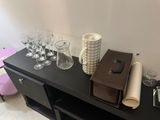 a table with a bunch of wine glasses and a bag on it
