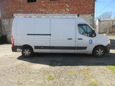 une camionnette blanche garée devant un immeuble en briques