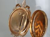 a gold locke on display with a mirror in the background