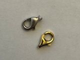 two pieces of silver and gold metal on a white surface