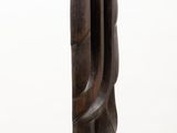 sculptures made of wood on a white pedestal against a white wall