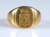 un gros plan d'une bague en or ornée d'un blason