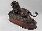 bronze statue of a lion on a rock on a white background