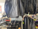 de nombreuses vestes et pantalons suspendus à un portant dans un magasin