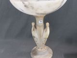 un socle antique en marbre surmonté d'un oiseau