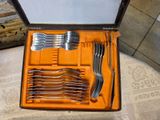 many forks and spoons in a case on a table
