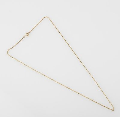 a gold necklace with a triangle shaped pendant on a white background