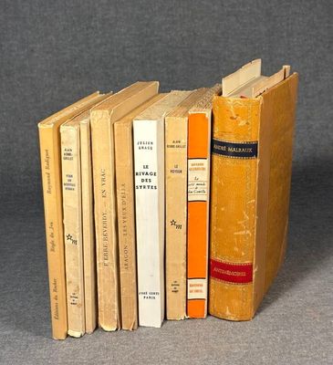 several books are stacked on top of each other on a gray surface