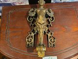 une petite table en bois sur laquelle se trouve une statuette en laiton