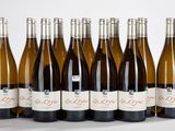 six bouteilles de vin sont alignées sur une surface blanche