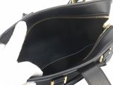 a black purse with a white cat inside of it