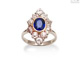 a close up of a ring with a blue stone surrounded by diamonds