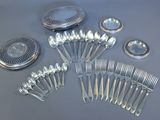 a lot of silver spoons and spoons on the table