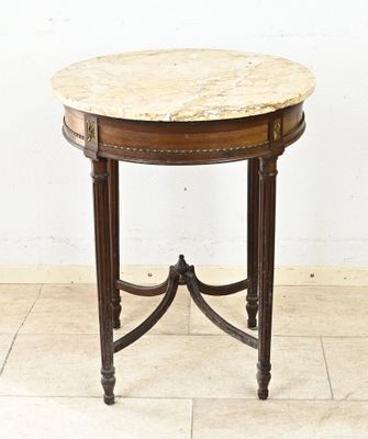 une photo d'une table d'appoint avec un plateau en marbre posée sur un sol carrelé