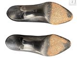 two pairs of black shoes with gold glitters on them