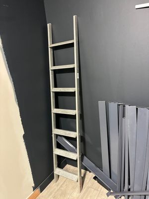 une échelle appuyée contre un mur noir dans une pièce