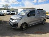 une camionnette argentée garée sur un parking à côté d'autres véhicules