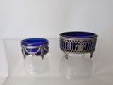 two blue glass bowls sitting on a glass table