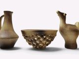 trois vases posés l'un à côté de l'autre sur une surface blanche