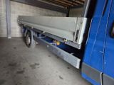 a blue truck with a flat bed in a garage