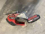 a picture of a cordless saw and a tool on the ground