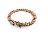 a gold bracelet with a clasp on a white background