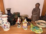 de nombreux vases de toutes sortes posés sur une étagère en bois dans une pièce