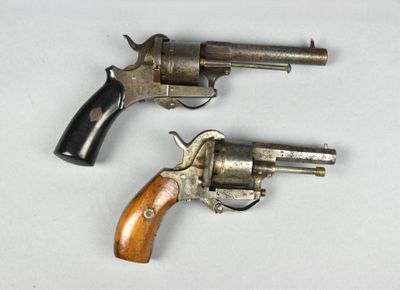 deux revolvers posés sur une surface blanche