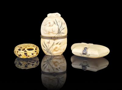 three carved objects on a reflective surface with a black background