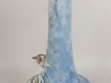a blue vase with a bird on it sitting on a table