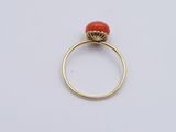 an image of a gold ring with a red stone in the middle
